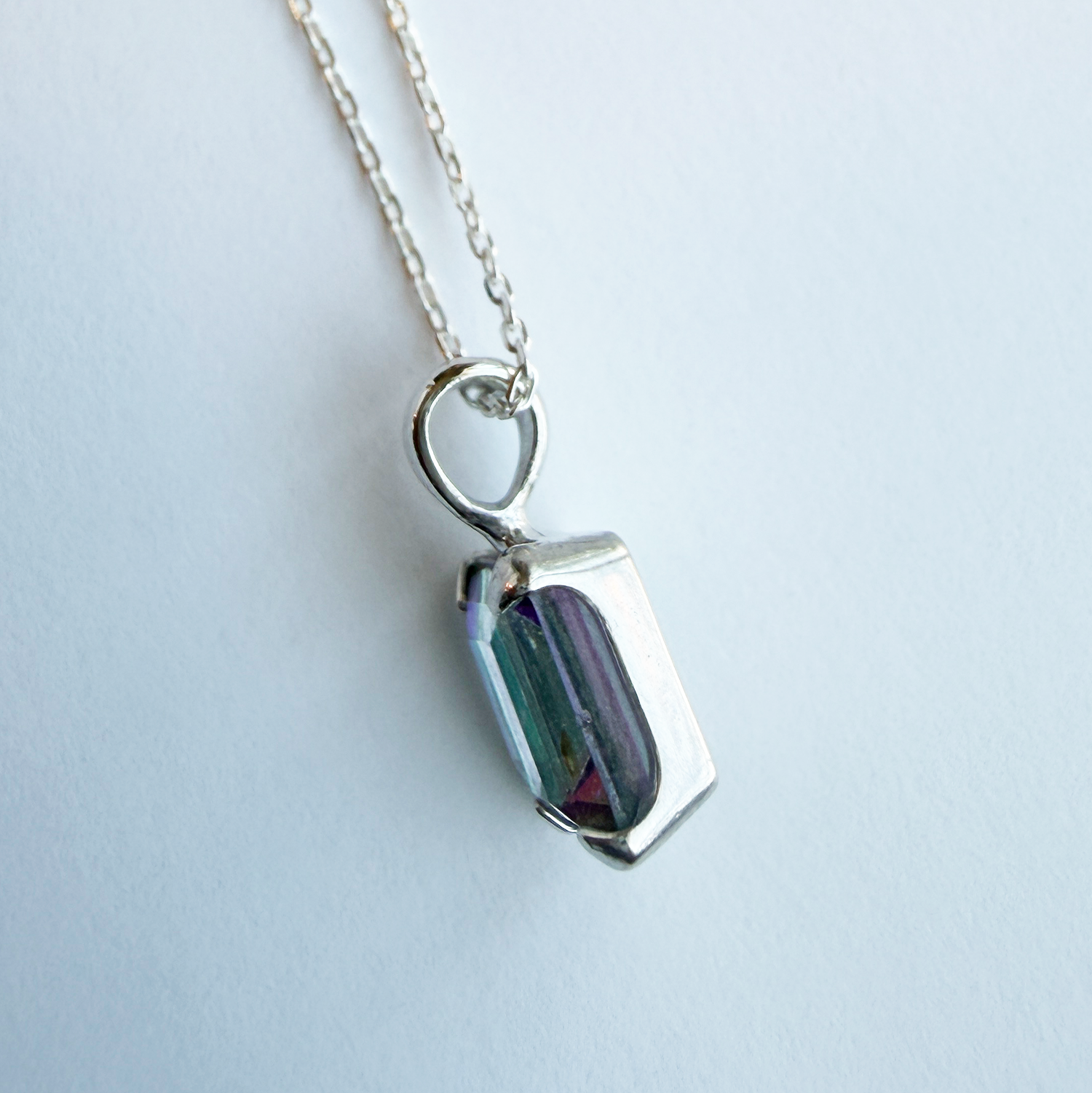 Sterling silver necklace with a mystic quartz pendant on a white background