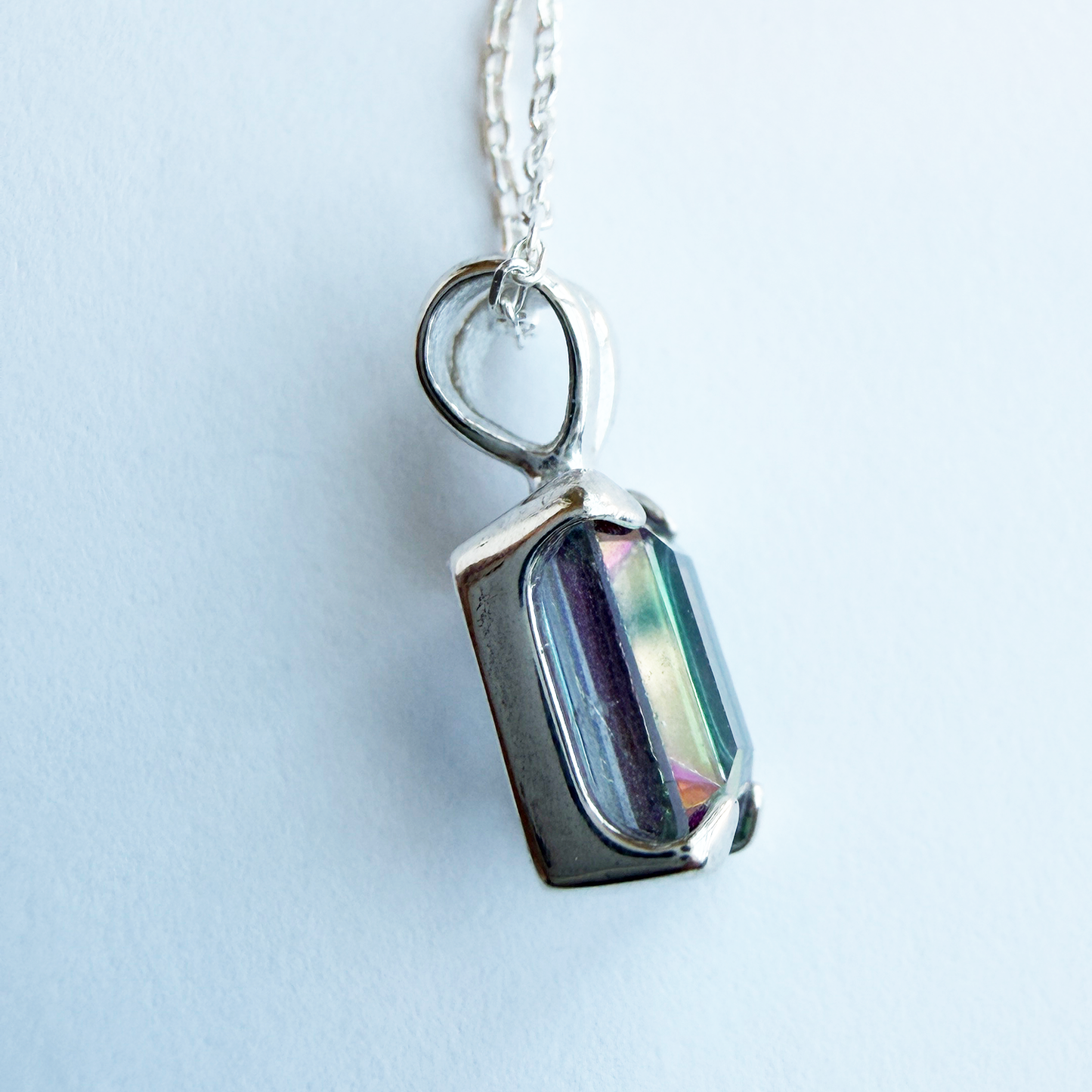 Sterling silver necklace with a pendant featuring a mystic quartz gemstone on a white background