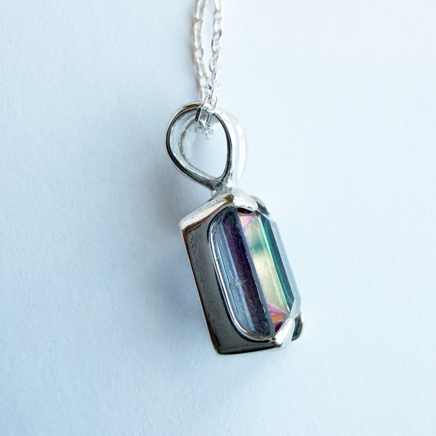 Sterling silver necklace with a pendant featuring a mystic quartz gemstone on a white background